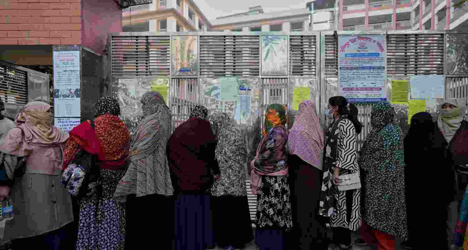 Bangladeshi women stand in queue to cast their votes in a polling station during national parliamentary election in Dhaka, Bangladesh. 