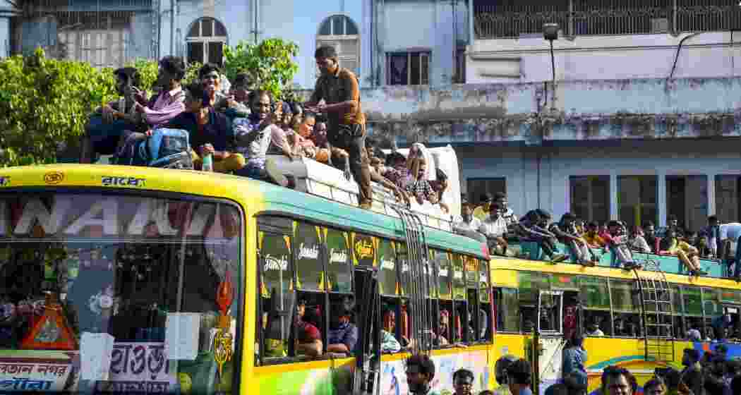 Passengers climb on bus roofs as they leave for their hometowns on the eve of the West Bengal Assembly elections, in Howrah district, on Wednesday.