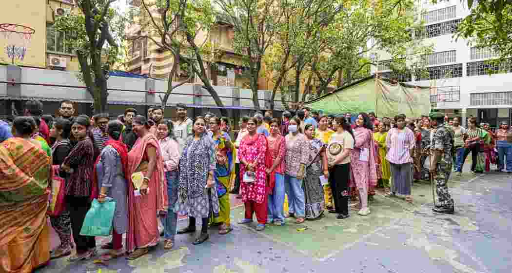 People wait in queues before casting votes in the second and final phase of the West Bengal Assembly elections, at a polling station in Kolkata, Wednesday.