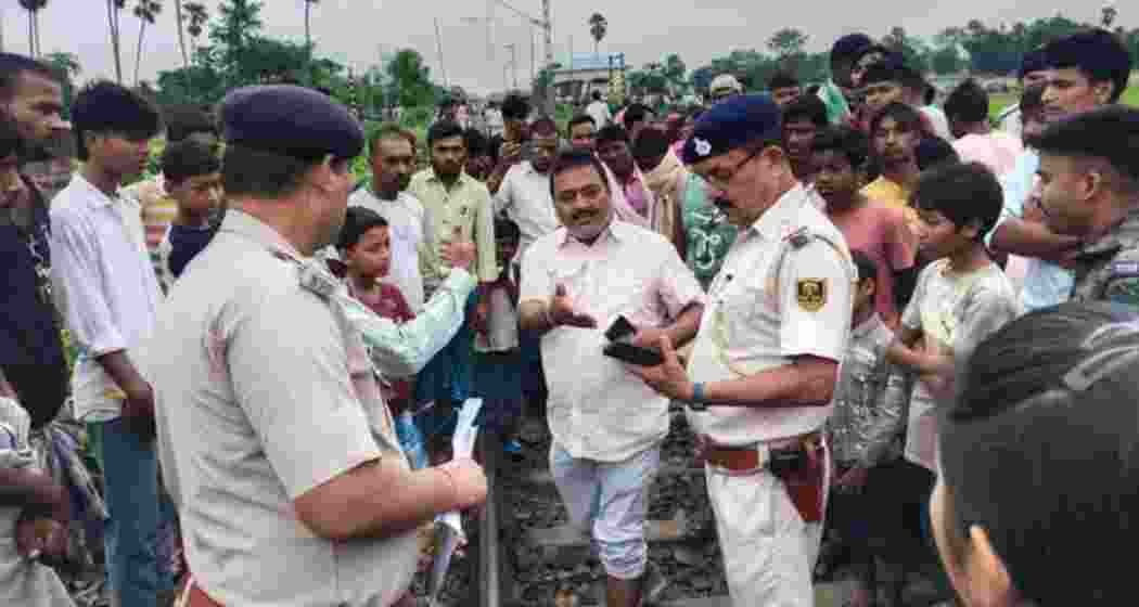 Locals, railway staff and police gather at the accident site in Purnea.
