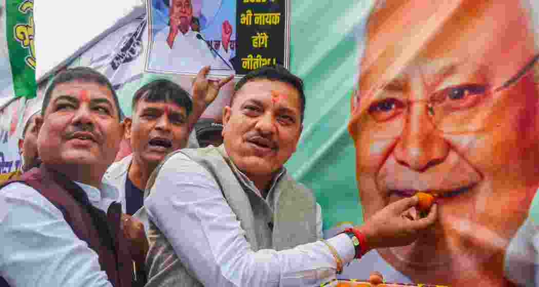 JDU members celebrate as the NDA alliance leads during the counting of votes of the Bihar Assembly elections, in Patna on Friday.
