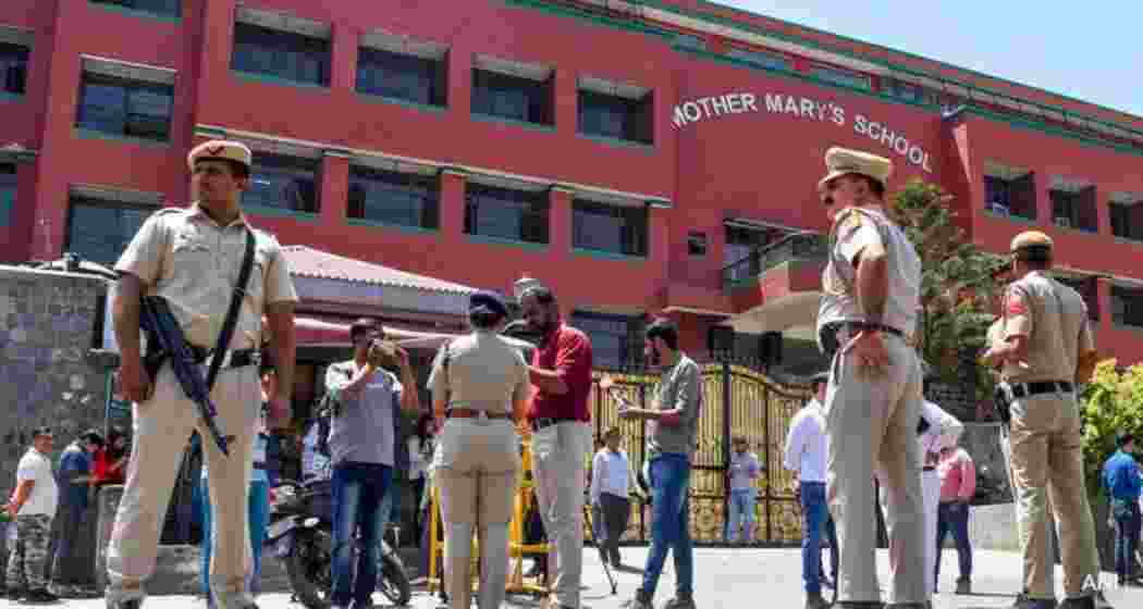 Delhi Police personnel and bomb disposal squads stationed outside The Mother's Mary School after a threat email triggered evacuations and security sweeps across more than 20 schools in the capital.