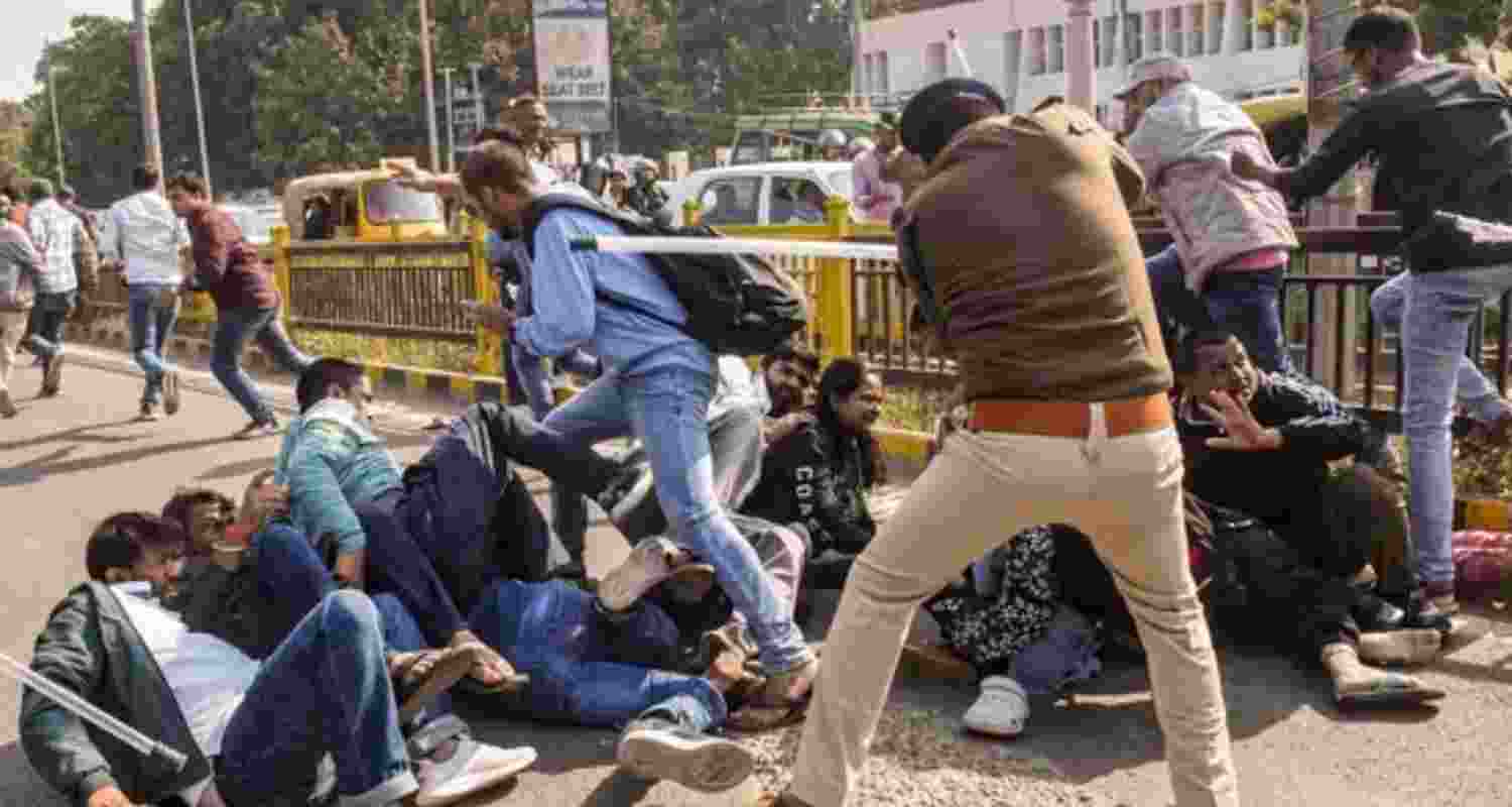 A police official lathicharges aspirants during their protest over normalisation of the 70th Bihar Public Service Commission (BPSC) examination in Patna.
