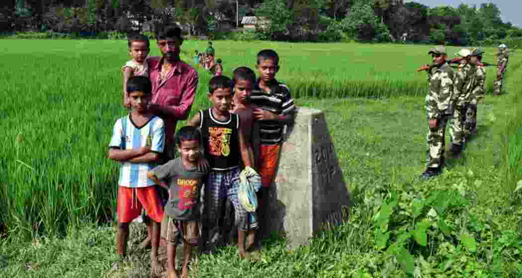 A family poses beside Border Pillar 2058, one of several markers demarcating India’s 4,096-km border with Bangladesh.