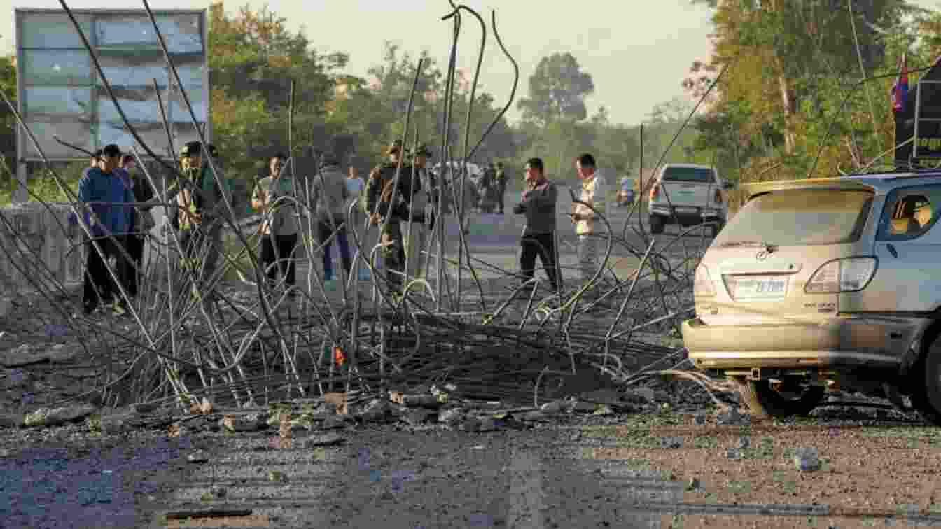 People look at a damaged bridge after Thailand carried out air strikes in an area between Cambodia's Oddar Meanchey and Siem Reap provinces.