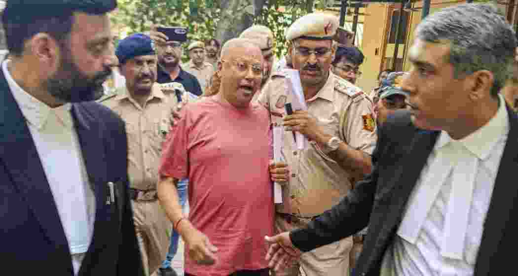 Police escort Chaitanyananda Saraswati outside Patiala House Court in Delhi.