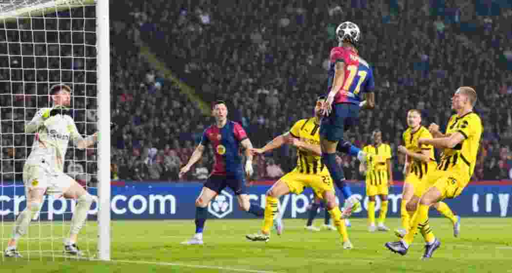 Raphinha of Barcelona heads the ball across the goal before his teammate Robert Lewandowski scores his team’s second goal.
