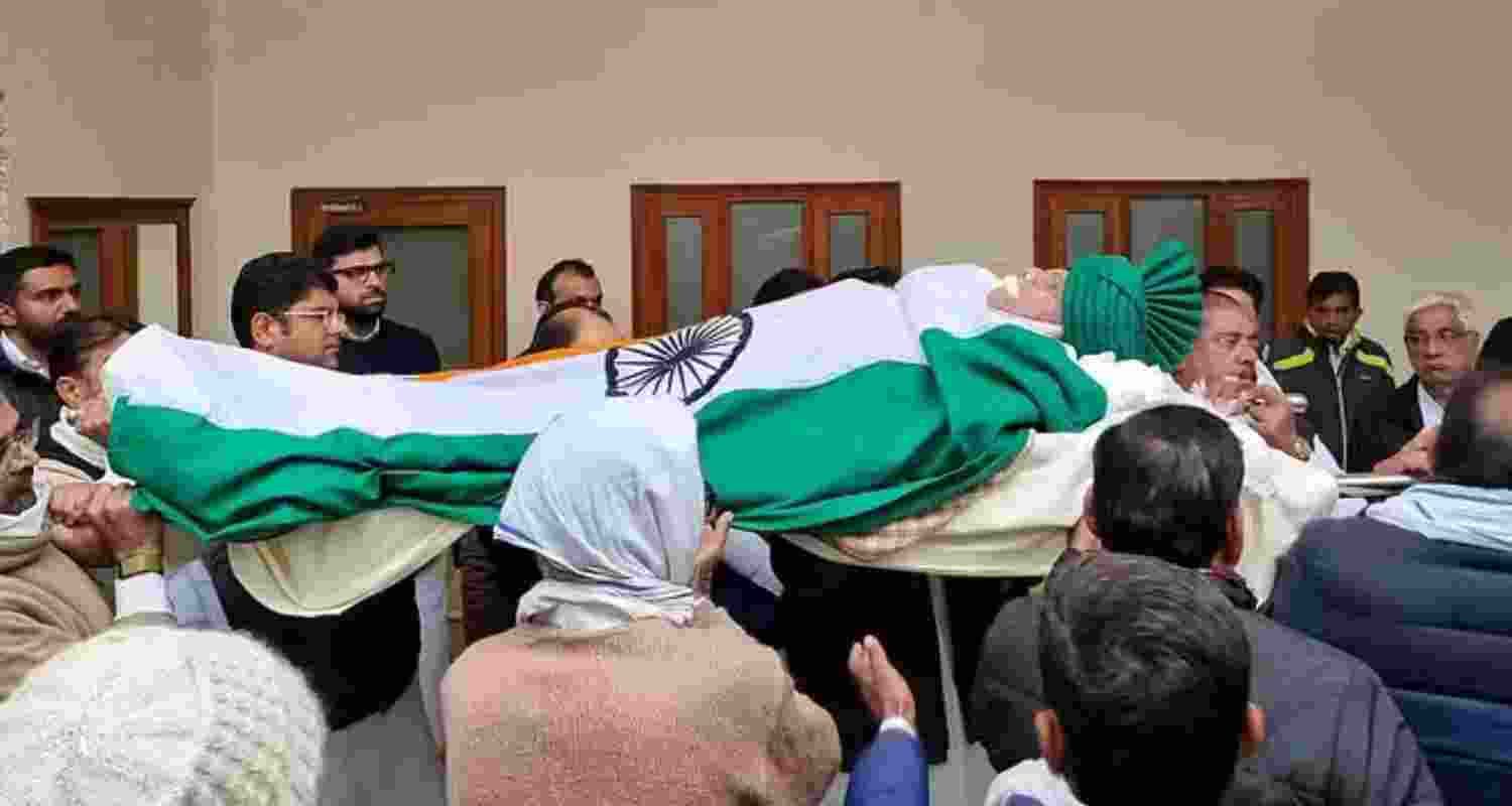 Om Prakash Chautala's body draped in the tricolour, adorned with a green turban and glasses.