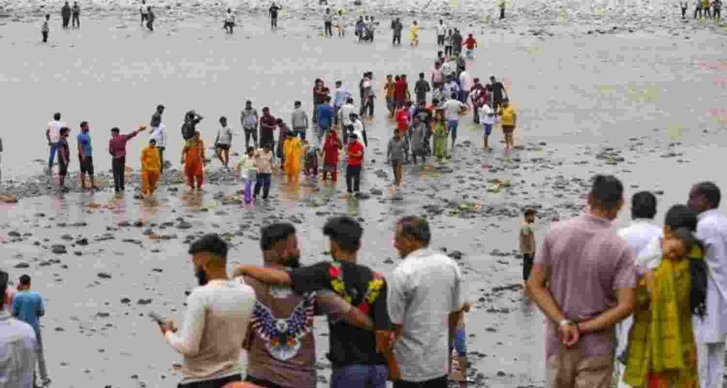 People walking on foot in river Chenab at Akhnoor as water level decreases to below knee onTuesday.