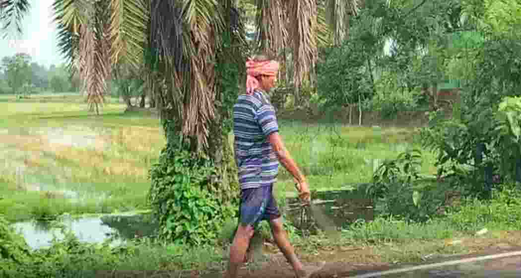 Bimal Mandal, 57, walks towards a police station holding his sister-in-law’s severed head on Saturday.