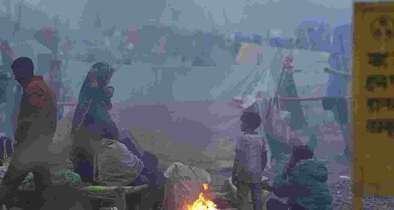 People warm themselves near a makeshift fire on a cold winter morning, in New Delhi, Monday. 