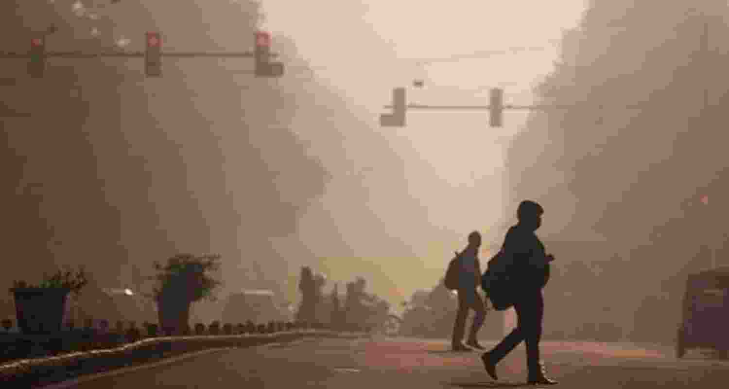 Commuters endure the early morning winter smog and cold in Dwarka, New Delhi, on Sunday.