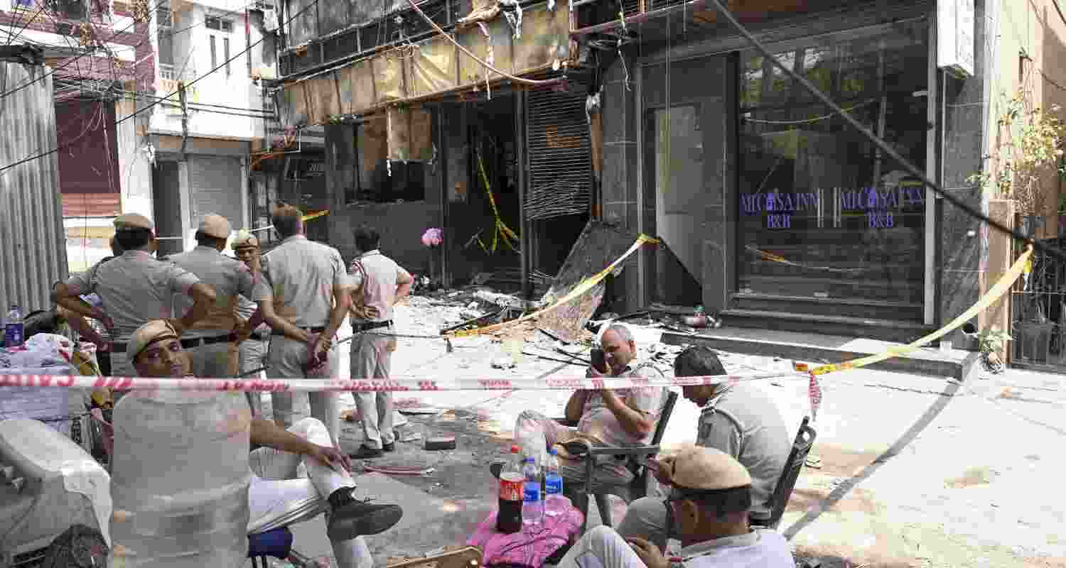 Police personnel keep a vigil at the spot a day after a fire at the Flourish Stay B&B killed at least 21 people, including 12 foreigners, at Hauz Rani area of Malviya Nagar, in New Delhi, Thursday, June 4, 2026.