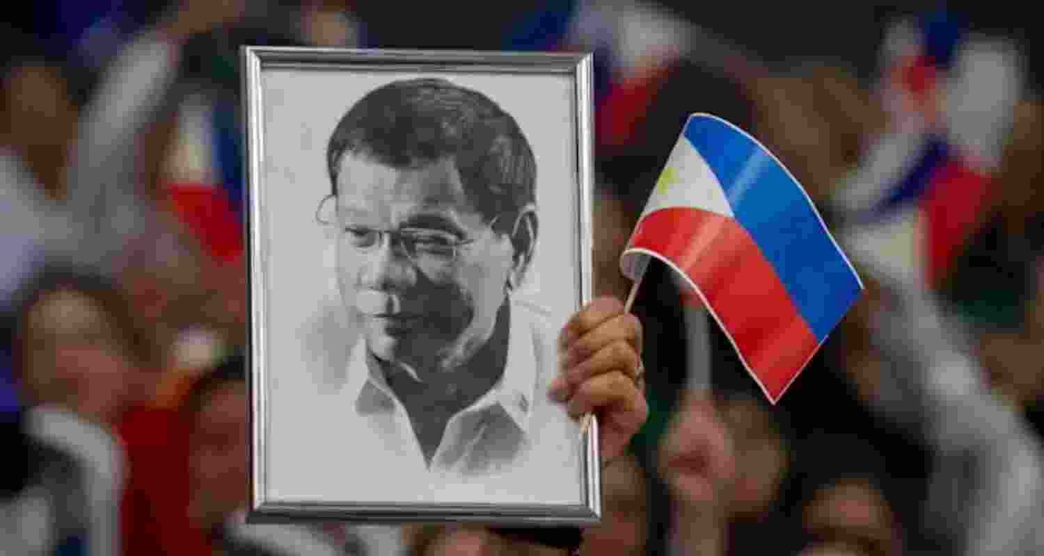 A supporter holds a portrait of former Philippine President Rodrigo Duterte at a campaign rally in Hong Kong Southorn Stadium on March 9, 2025.