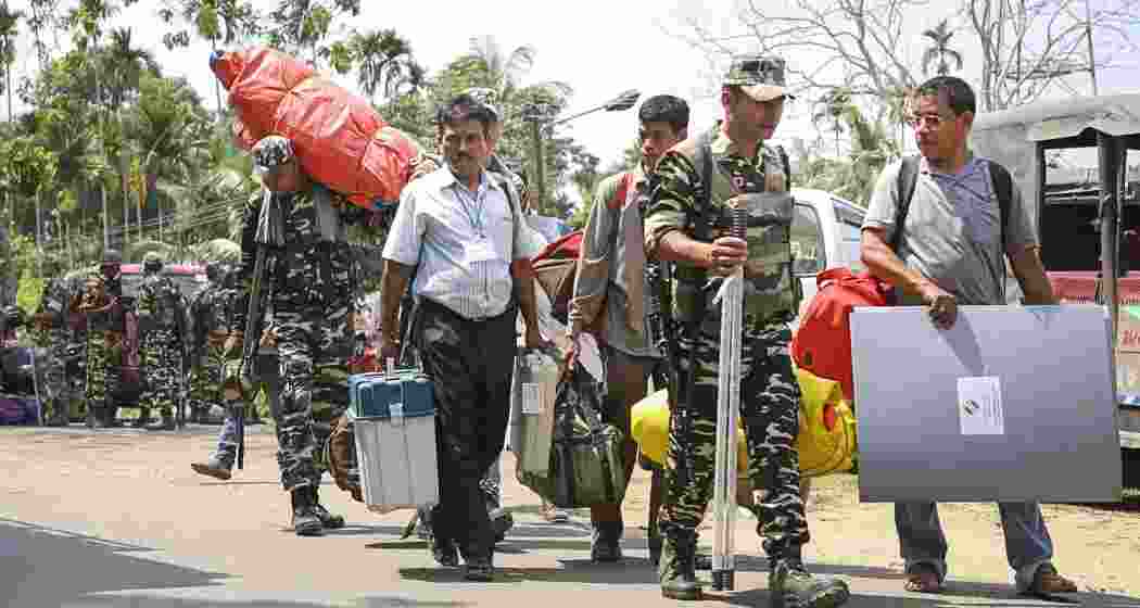 Polling officials along with security personnel carrying EVMs, VVPAT and other election material depart from a distribution centre, to polling booths on the eve of Bye-election for the 56-AC Dharmanagar assembly seat, in North Tripura district, on Wednesday.