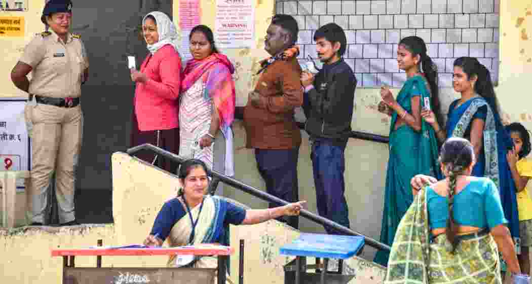 People wait in a queue to cast their votes at a polling booth during the Maharashtra local body, in Nagpur. (PTI)