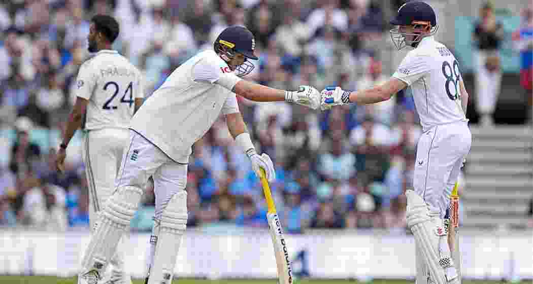 England's Harry Brook celebrates his half century with teammate Joe Root during the fourth day of the fifth Test match between India and England, at The Oval cricket ground, in London on Sunday.