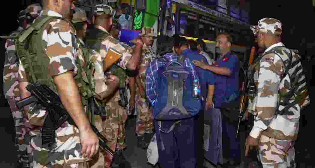 Polling officials carry electoral materials to strong rooms while security personnel keep a vigil, after the conclusion of the West Bengal Assembly elections, at Santipur, in Nadia district, West Bengal, Wednesday.