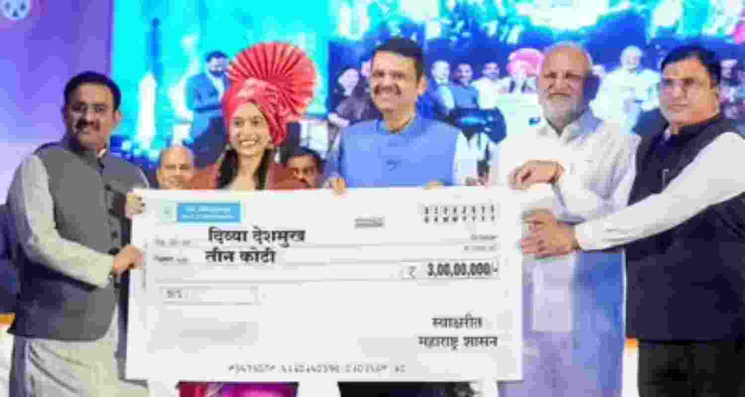 Maharashtra Chief Minister Devendra Fadnavis handing over a cash award of Rs 3 crore to newly-crowned FIDE Women's World Cup champion Divya Deshmukh in Nagpur on Saturday.