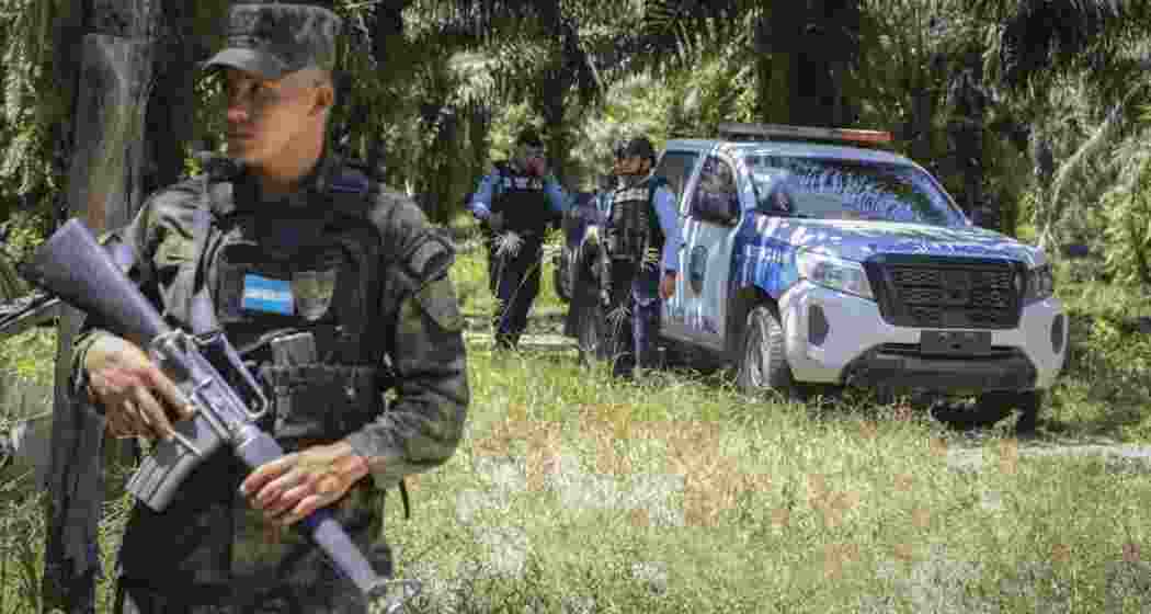Honduran soldiers and police officers guard the site of a massacre in Trujillo on Thursday.