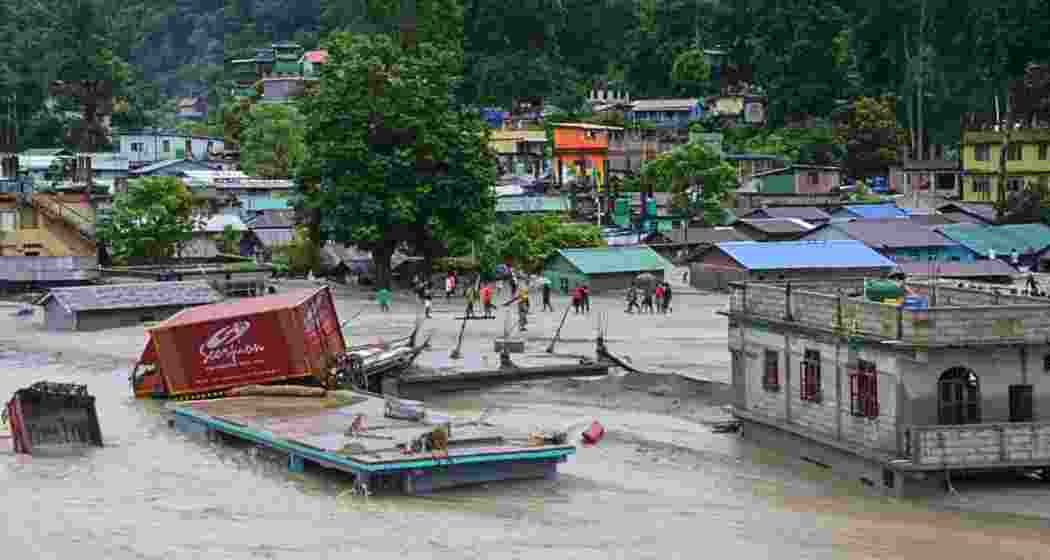 A vehicle that got washed away lies atop a submerged building after flash floods triggered by a sudden heavy rainfall swamped Rangpo town in Sikkim.