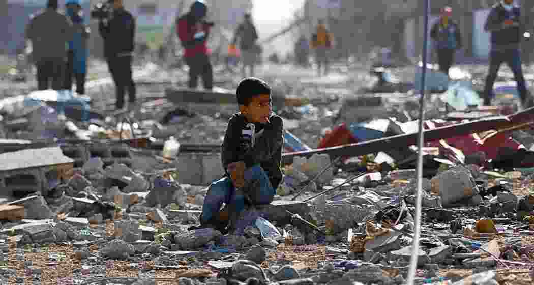 A Palestinian child sits among the rubble of homes destroyed in an Israeli strike in Khan Younis in the southern Gaza Strip.