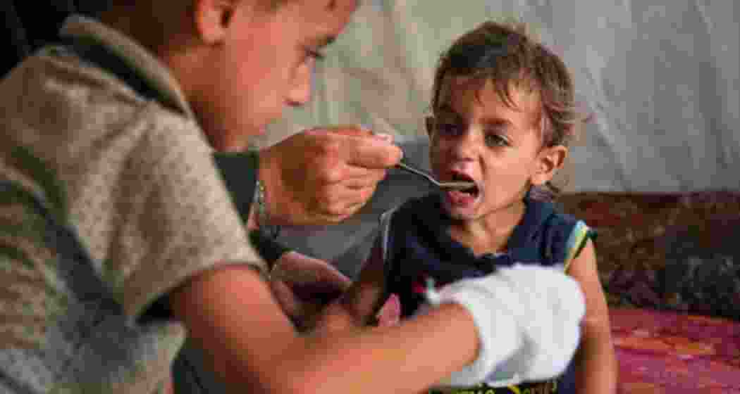 A Palestinian boy receives a meal from a community kitchen at the Muwasi displacement camp in Khan Younis, Gaza, on May 18.