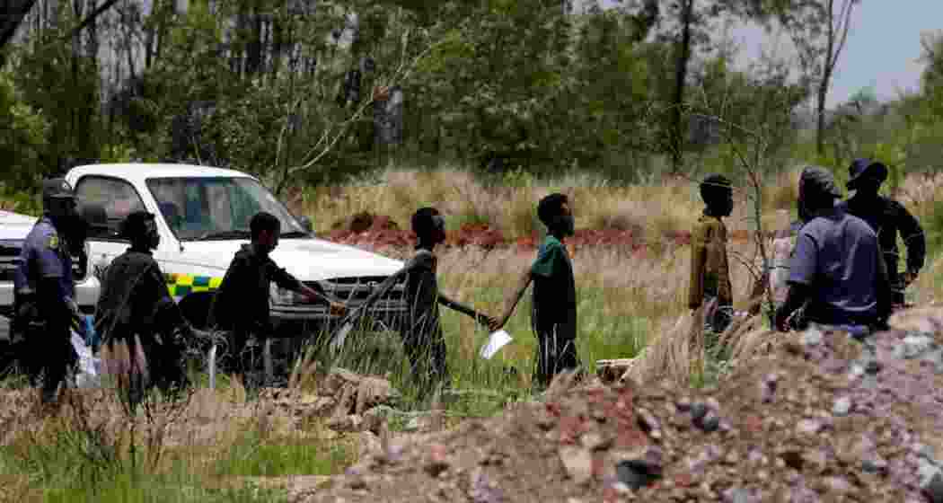 Illegal miners escorted by police officers after being rescued from an abandoned gold mine in Stilfontein, South Africa.