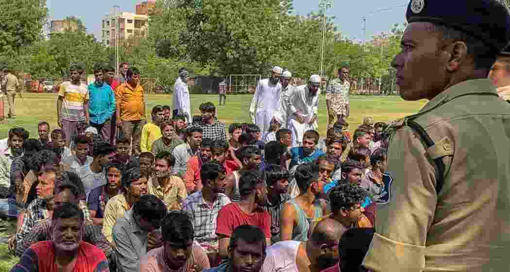 Detained Bangladeshi migrants  at a crime branch office after an overnight police crackdown in Ahmedabad on April 26, 2025. Over 1,000 “migrants” were rounded up to be identified and deported.  (Image: SAM PANTHAKY)