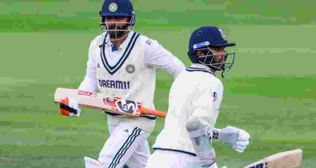 Ravindra Jadeja and Washington Sundar scamper through for a quick single on Day Five at Old Trafford on Sunday.