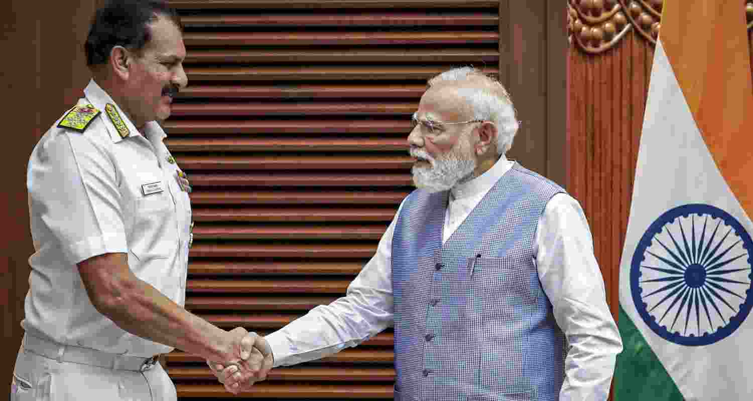 Prime Minister Narendra Modi, right, exchanges a handshake with outgoing Chief of the Naval Staff (CNS) Admiral Dinesh K Tripathi during a meeting.