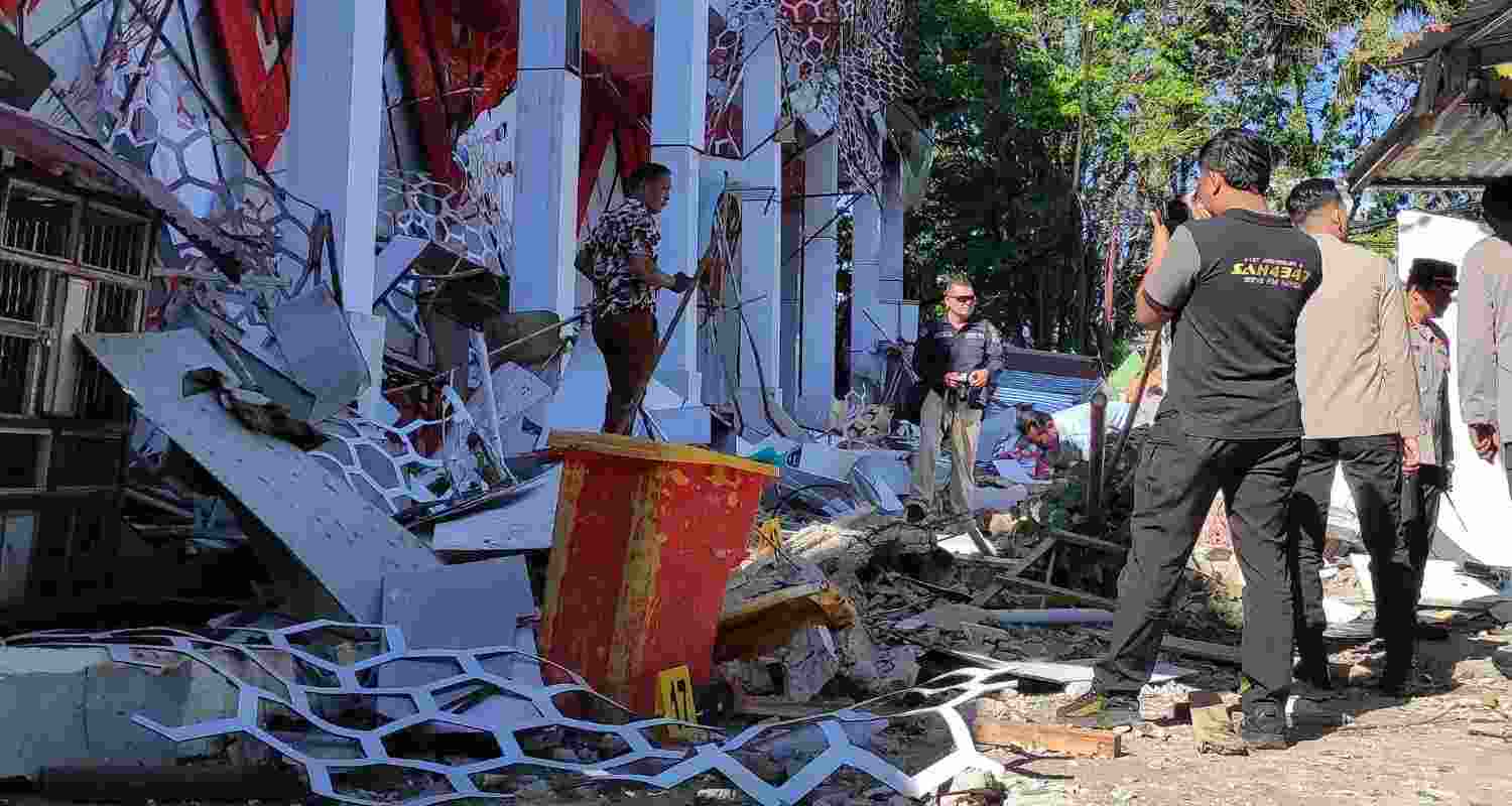 Police officers inspect a damaged building following an earthquake in Manado, North Sulawesi, Indonesia. 