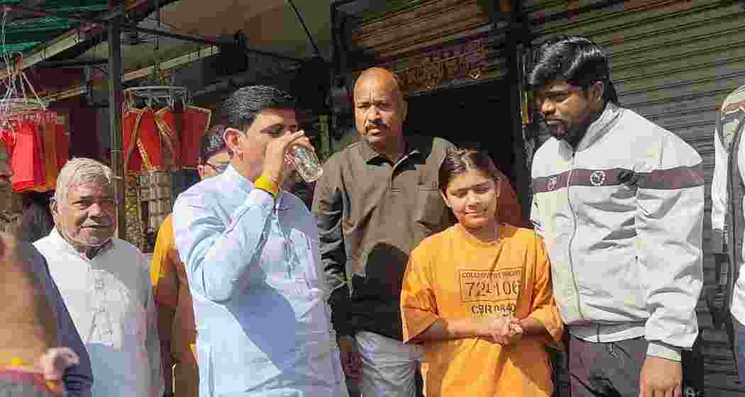 Indore Mayor Pushyamitra Bhargav drinks tap water during a visit to Sudama Nagar on Monday to counter Congress allegations of contamination.