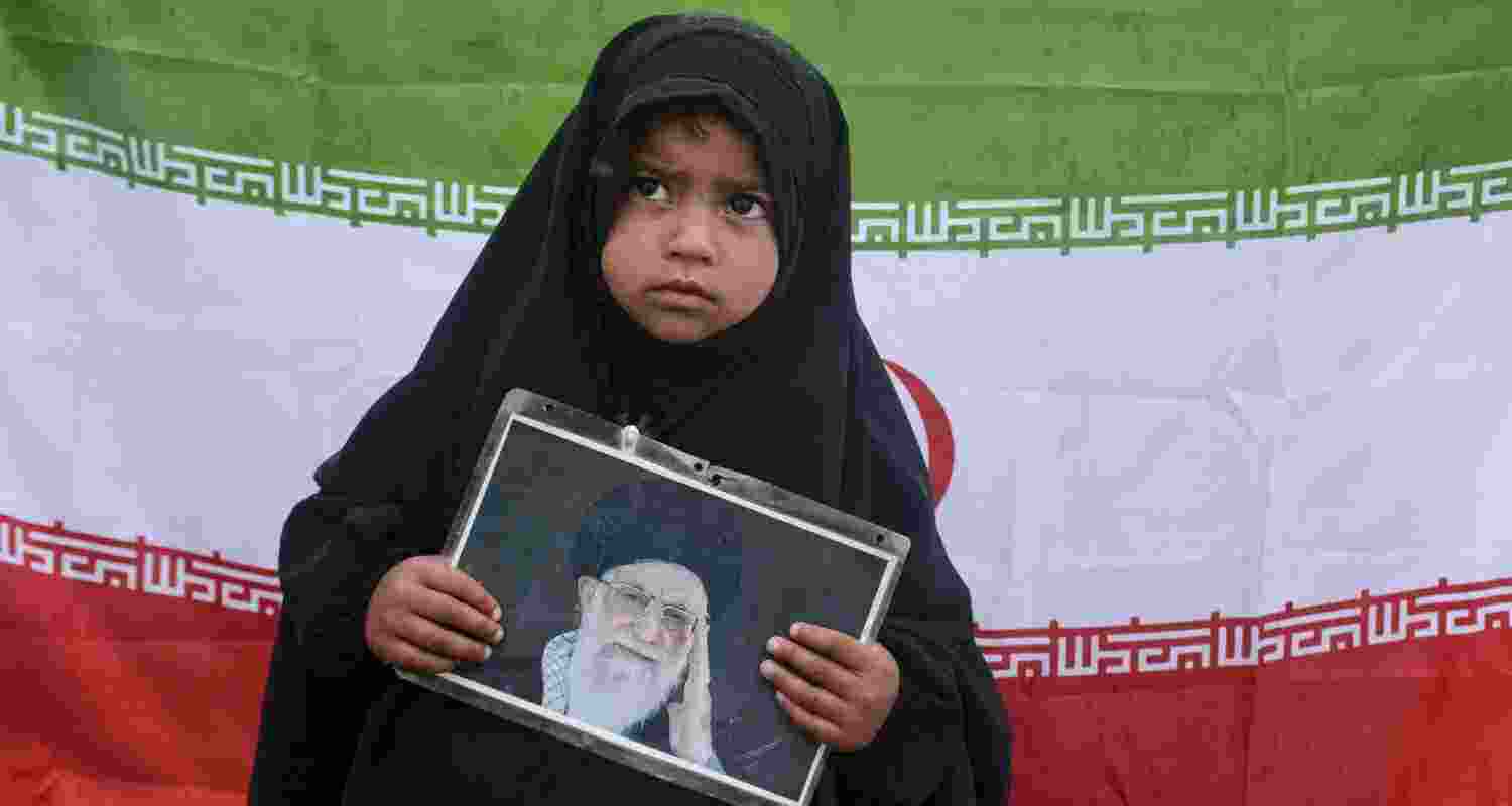 A girl holds a portrait of late Iran's Supreme Leader Ayatollah Ali Khamenei, in response to the ceasefire agreement between Iran, the United States and Israel. 