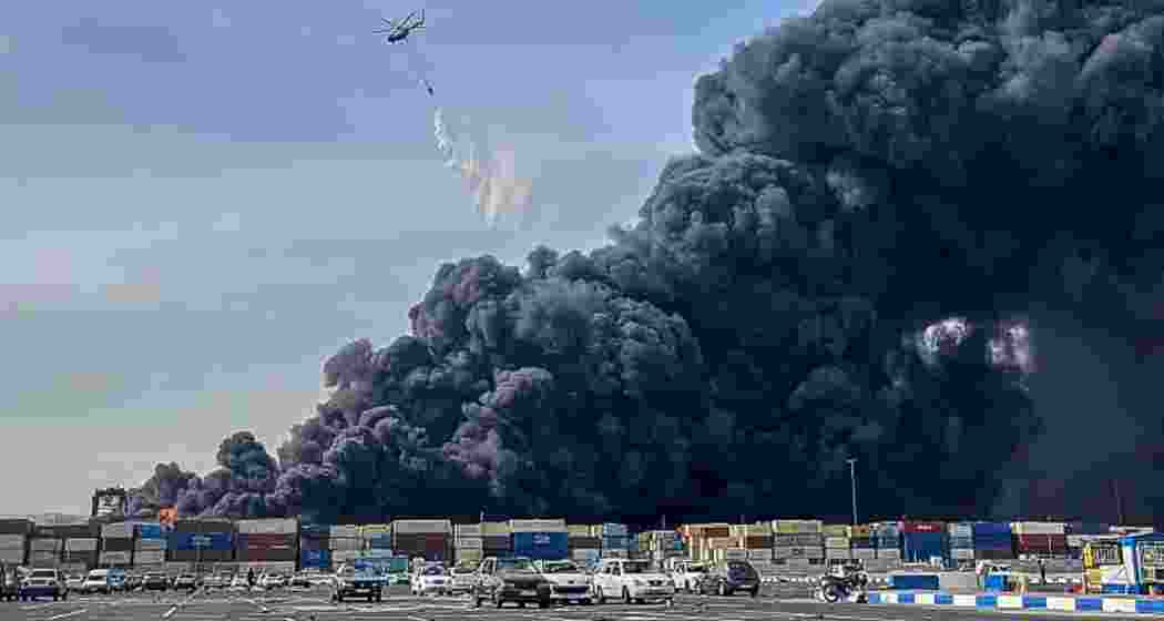 A helicopter douses the massive fire at Shahid Rajaei port in Iran after an explosion linked to missile fuel chemicals killed 18 people and injured hundreds on Saturday (local time).