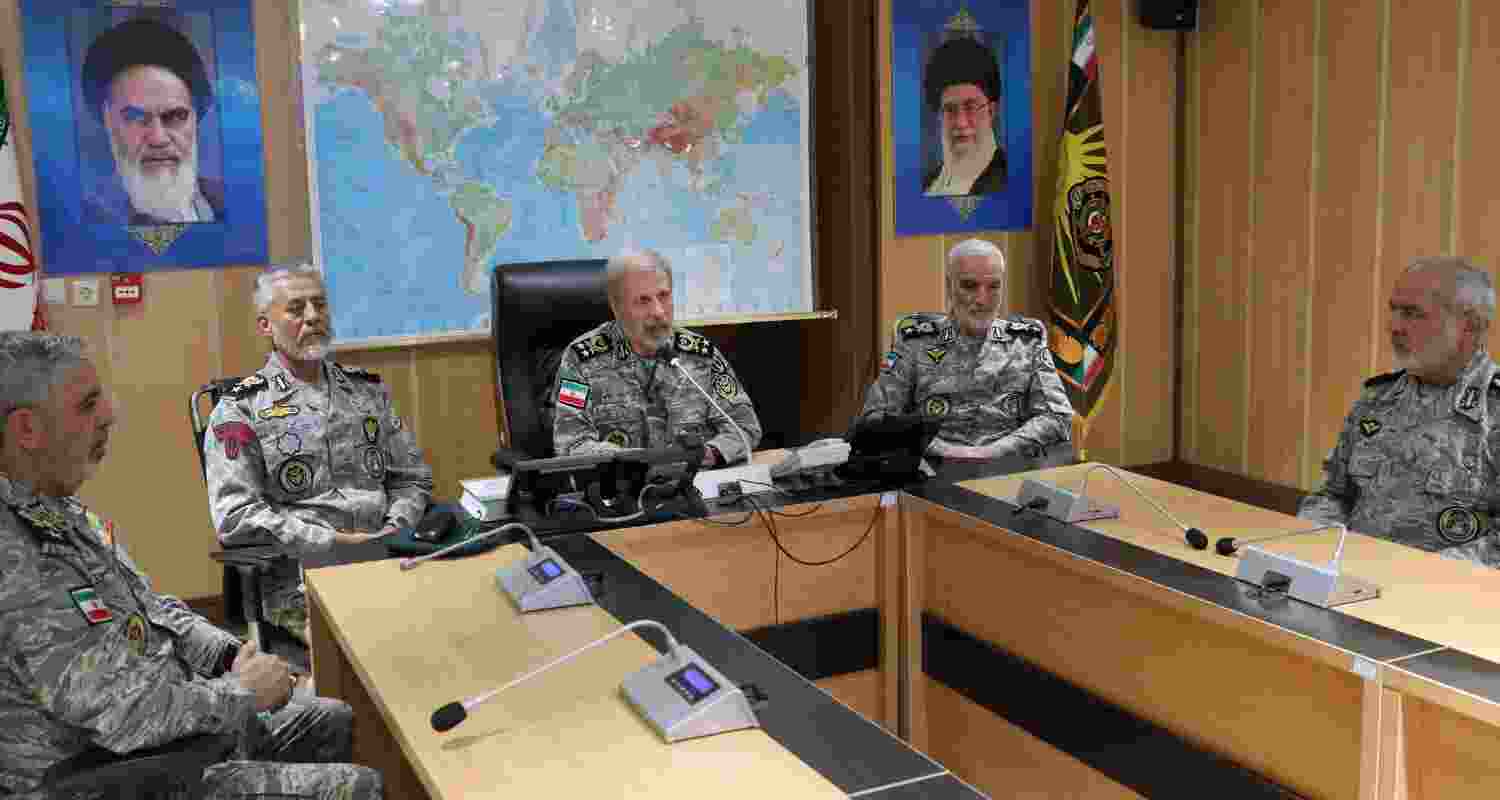 Iran's army commander-in-chief Gen. Amir Hatami, center, accompanied by high ranked army commanders, speaks in a video call with top commanders of the army, in Zolfaghar central headquarters, Iran, as portraits of the late revolutionary founder Ayatollah Khomeini, left, and Supreme Leader Ayatollah Ali Khamenei hang on the wall.