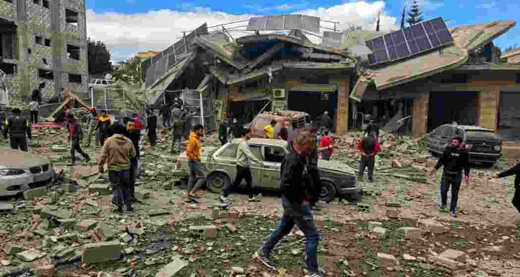 Lebanese people inspect the destruction of a building that was targeted in an Israeli air strike in the southern Lebanese village of Touline on March 22, 2025.