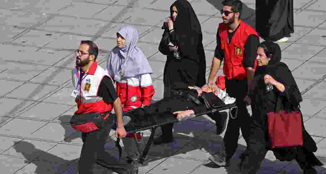 Red Crescent personnel carry an elderly woman on a stretcher who had fainted in the crowd at the Grand Mosalla during the funeral ceremonies for Iran's slain supreme leader Ayatollah Ali Khamenei, in Tehran on July 4, 2026. Funeral ceremonies for Iran's supreme leader Ali Khamenei officially began on July 4, state television reported, an event drawing thousands and intended to serve as a show of strength to the Islamic republic's foes.(AFP)