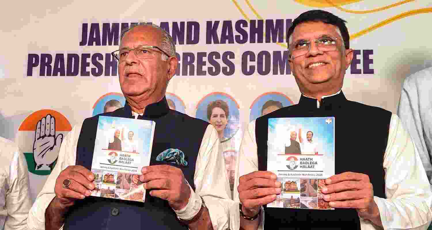 Congress leader Pawan Khera with JKPCC chief Tariq Hameed Qara releases party's manifesto for upcoming Assembly elections, in Srinagar, Monday. Congress leader Pawan Khera with JKPCC chief Tariq Hameed Qara releases party's manifesto for upcoming Assembly elections, in Srinagar, Monday.