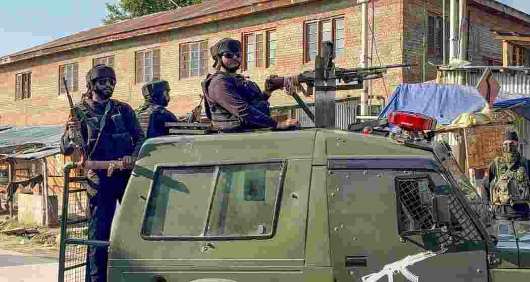 Security personnel keep a vigil amid an ongoing encounter between security forces and terrorists in a forest area at Akhal, in Kulgam district, Jammu and Kashmir, Sunday.