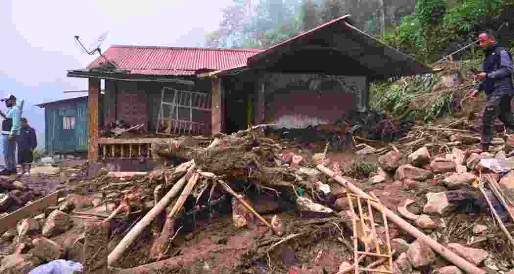 A mudslide triggered by heavy rains destroys a house near Mirik in the Darjeeling hills.
