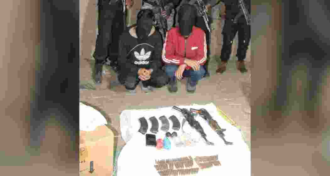 The two Lashkar-e-Taiba hybrid militants apprehended in Shopian, with recovered weapons and ammunition including rifles, grenades, and rounds, following a joint operation by Army, police, and CRPF forces.