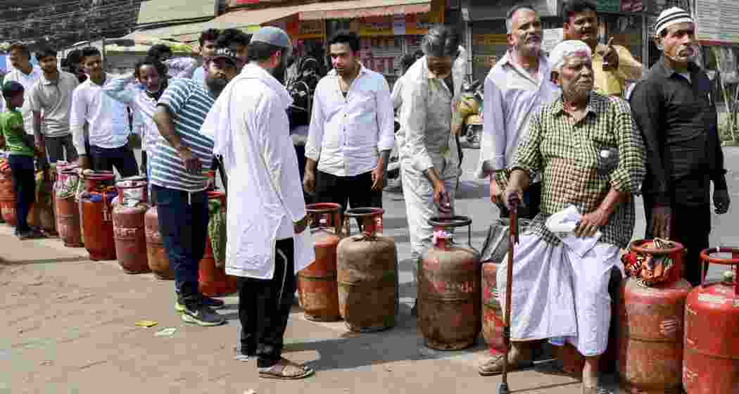 People wait in a queue with empty LPG cooking gas cylinders to avail refilled ones, amid a shortage linked to the ongoing West Asia conflict affecting the global energy supply chain, in Prayagraj, on Wednesday.