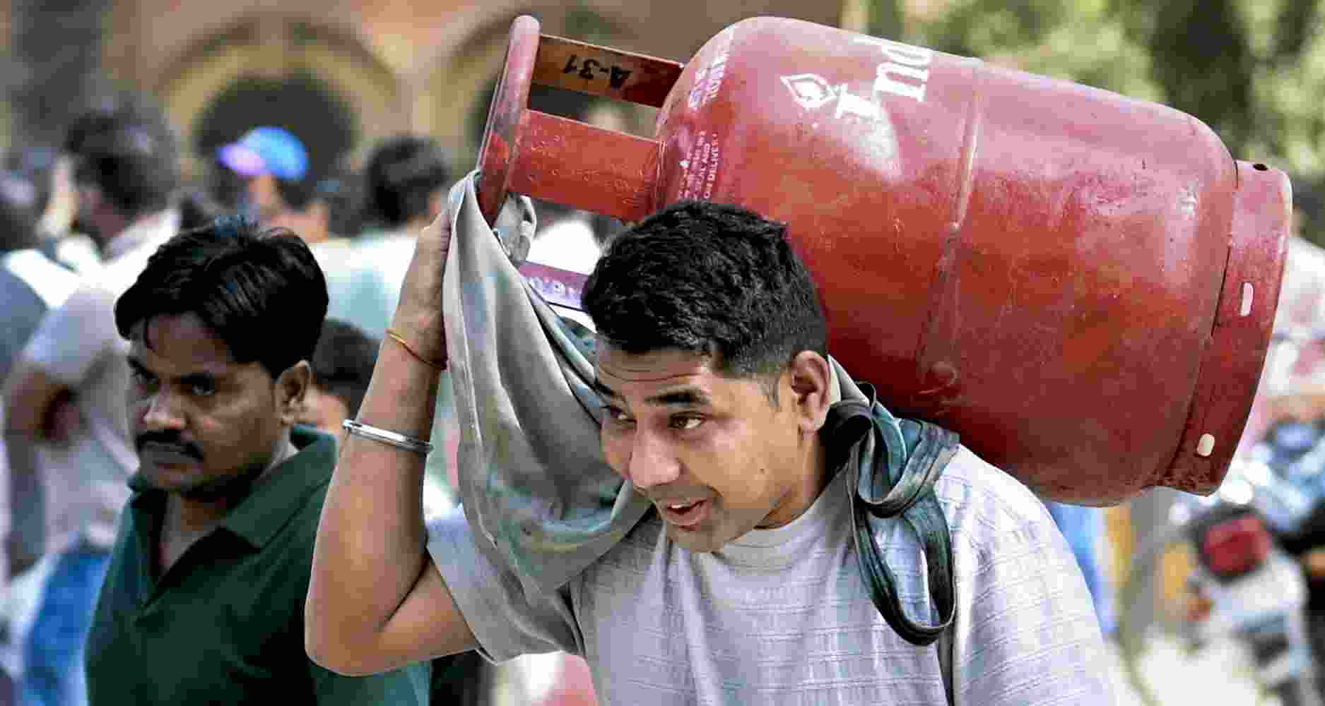 A man carries a refilled LPG cooking gas cylinder, amid a shortage linked to the ongoing West Asia conflict affecting the global energy supply chain, in Prayagraj, Wednesday, March 18, 2026. 
