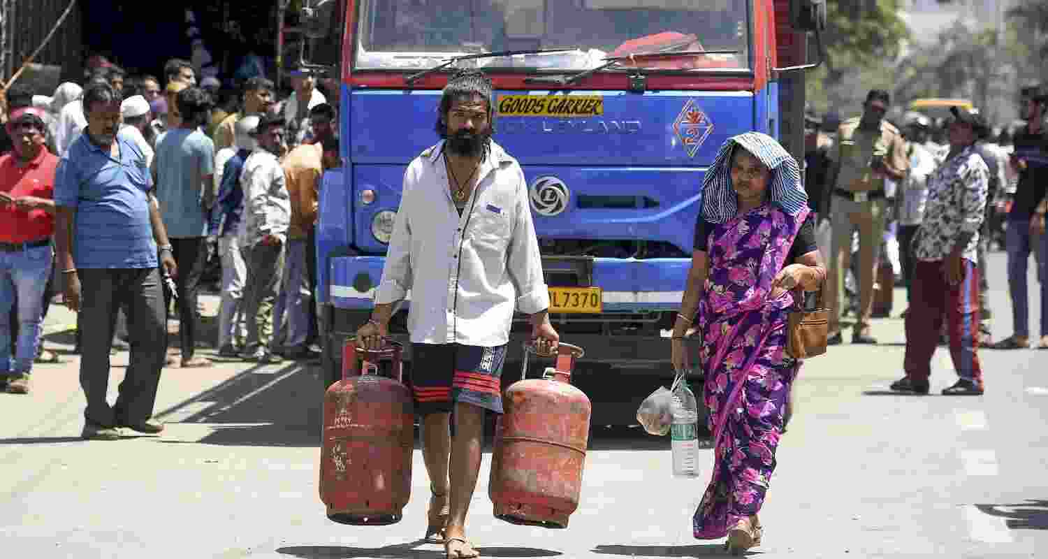 A man carries empty LPG cylinders on a sunny afternoon, amid disruptions in LPG supplies due to the ongoing West Asia war, at Malad, in Mumbai, Maharashtra, Saturday, March 28, 2026. 