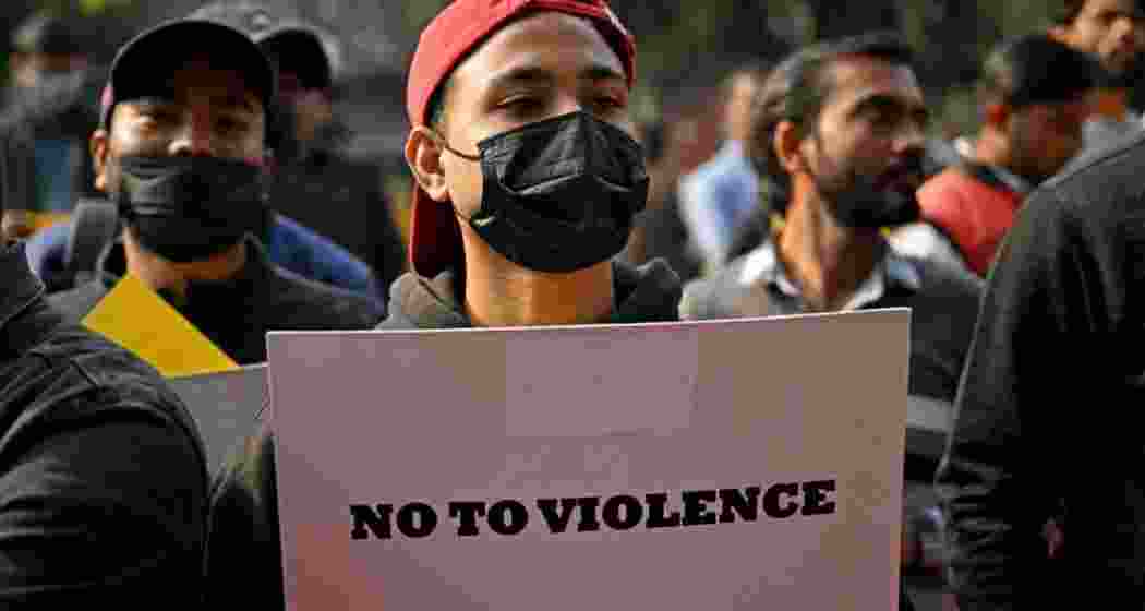 A demonstrator holds a placard during a protest in New Delhi on December 9, 2024, demanding restoration of peace in Manipur. 
