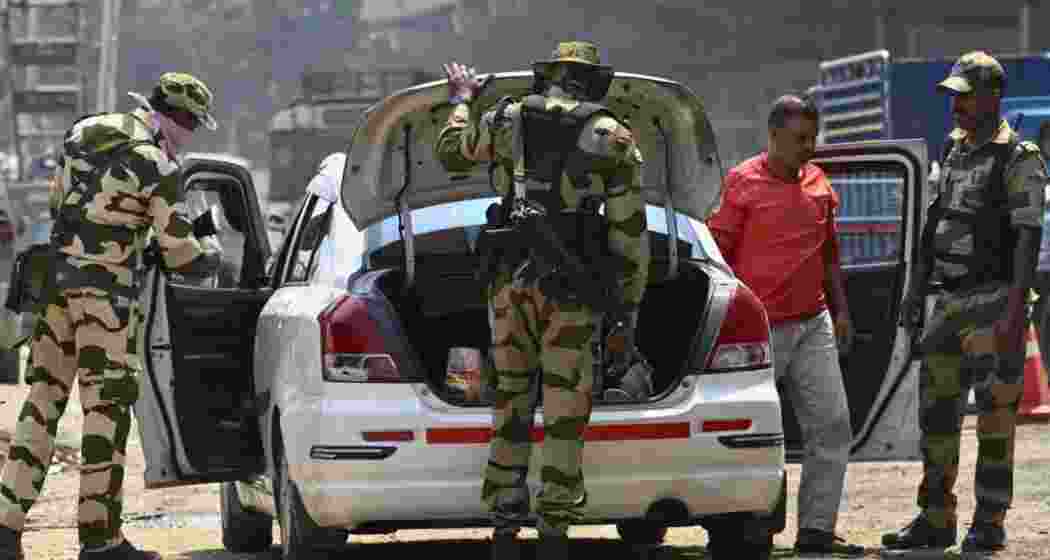Central Armed Force personnel check vehicles.