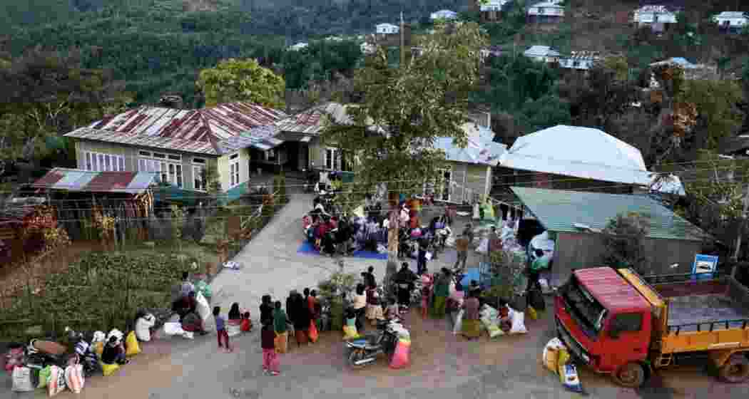 Displaced individuals from Myanmar gather at a temporary relief centre near the India-Myanmar border in Mizoram to collect donated clothing amid ongoing unrest and cross-border displacement.