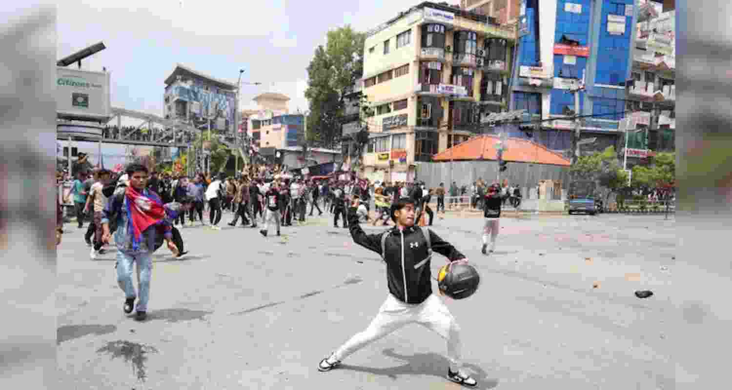 Protestors clash with the riot police outside the Parliament building in Kathmandu, Nepal, Monday.