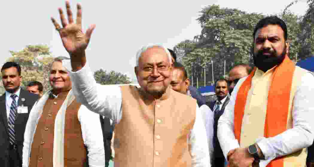 Bihar Chief Minister Nitish Kumar waves to supporters as Deputy Chief Minister Samrat Choudhary (R) looks on, in Patna.